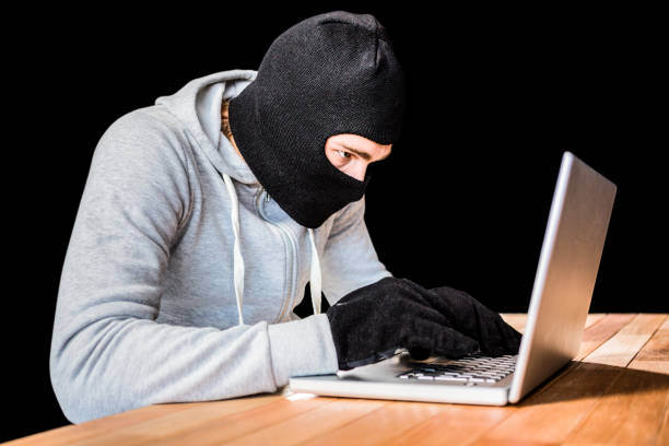 istock Focused thief with hood typing on laptop 845608974