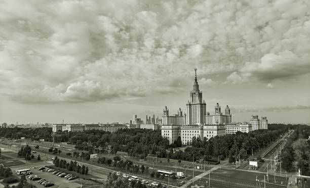 istock Black and white wide angle panoramic landscape view of dramatic clouds over the sunny summer campus of Lomonosov Moscow State University 845616376