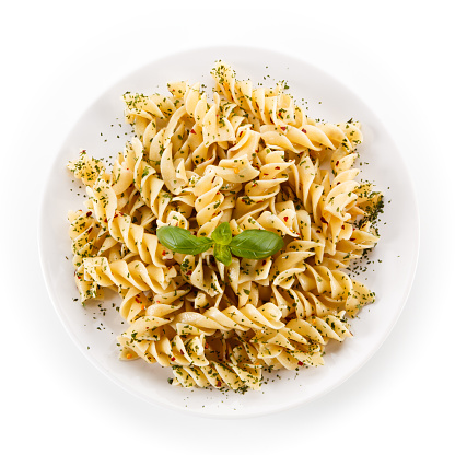 Fusilli, pesto sauce and vegetables on white background
