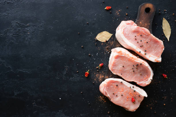 istock Raw meat with spices on a black background with space for text 845622864