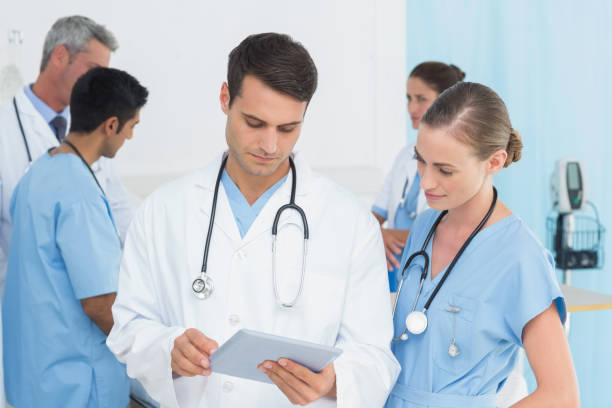 istock Report reading with colleagues and patient behind 845625788