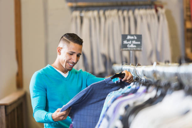 Close-up on shirts hanging on the rack at a menswear clothing store - small business concepts