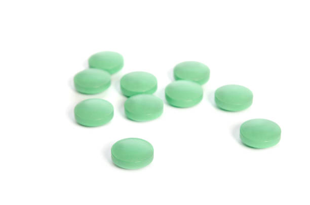 istock Pile of light green pills isolated on white background 845628280