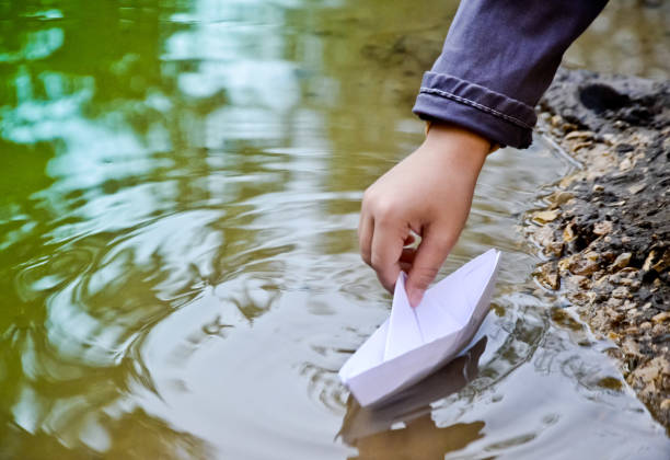 istock children's hand let the paper boat 845629112