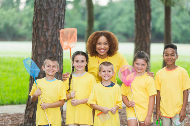 istock Children and counselor at summer camp in park 845629546