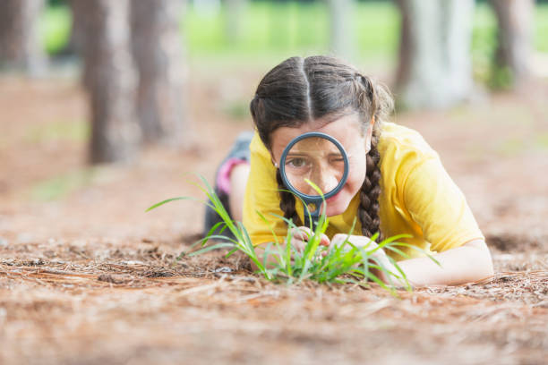 istock Girl exploring nature with magnifying glass 845629672