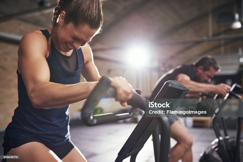 Sportifs de travailler dur sur machines de cyclisme - Photo de Exercice physique libre de droits