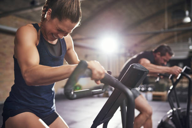 sportsmen working out hard on cycling machines - toughness imagens e fotografias de stock