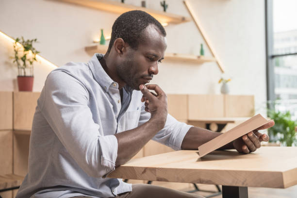 istock african-american man in cafe looking at blank menu list 845639408