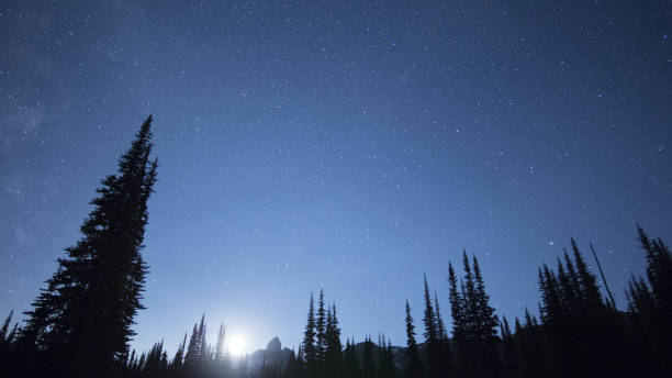 istock Brightly lit moon and night stars over a scenic mountain landscape 845639410