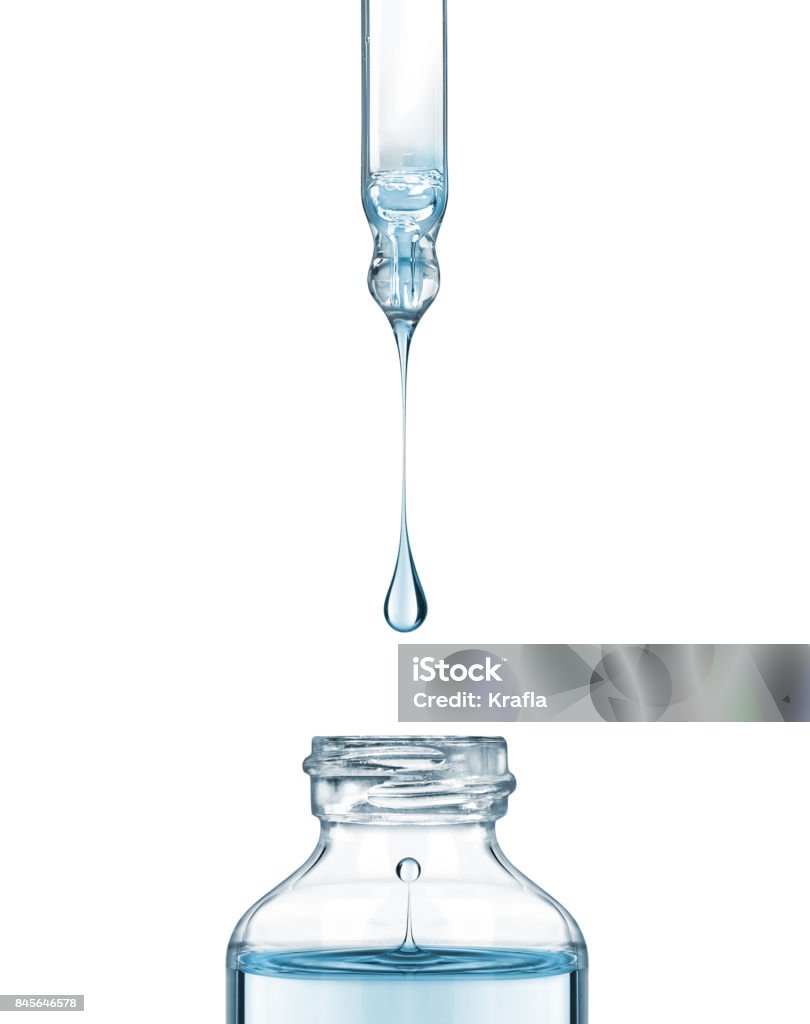 Drop falls from a pipette into a cosmetic bottle on white background Skin Care Stock Photo