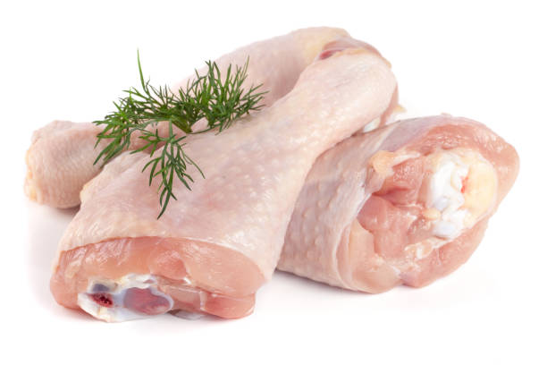 istock Three raw chicken drumsticks with a sprig of dill isolated on white background 845650376