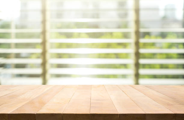 istock Wood table top with blur window shutters background 845663910