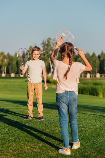 little children playing badminton together in park