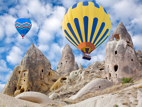 Colorful hot air balloons flying over the valley in Cappadocia, Anatolia, Turkey. Cappadocian Region with its valley, canyon, hills located between the volcanic mountains Erciyes, Melendiz and Hasan.