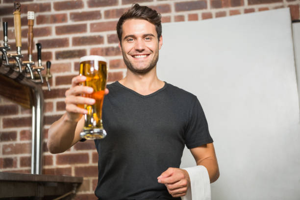 Handsome man holding a pint of beer in a pub