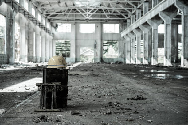 Interior of old factory buildings destroyed. Ruins of industrial enterprise, dark debris destroyed factory premises in factory as result of economic crisis and earthquake.