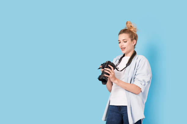 istock Woman photographer is satisfied about her work. Model isolated on a blue background with copy space 845681642