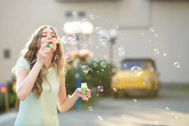 istock happy woman blowing soap bubbles 845682902