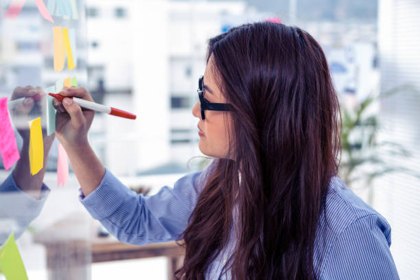 istock Asian businesswoman using sticky notes on wall 845687624