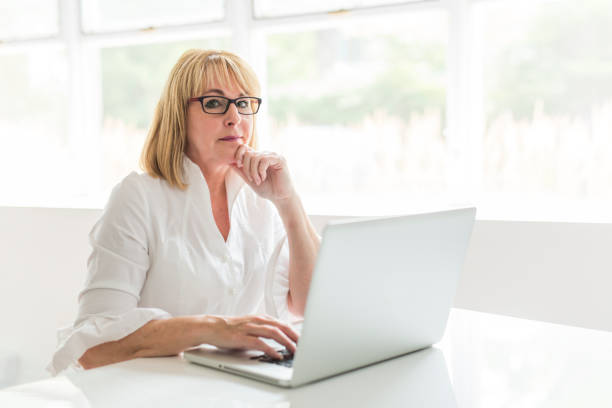 istock mature woman using laptop at home 845708396