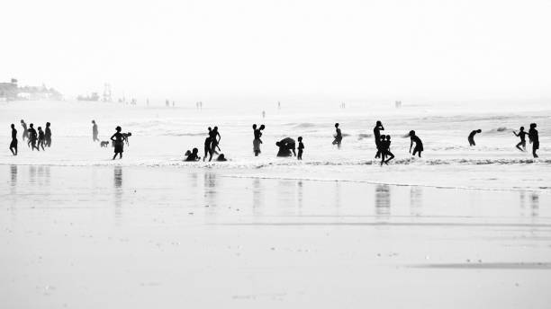 A portrait landscape in black and white of a reflective rocky beach in Denmark with impressive and contrasty clouds