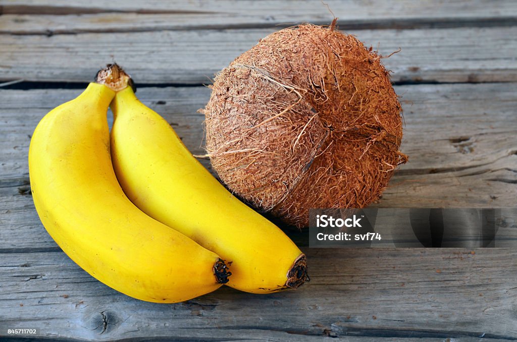 Bunch Of Ripe Organic Bananas And Coconut On Wooden Backgroundcoconut And  Bananasbanana Coconut Stock Photo - Download Image Now - iStock