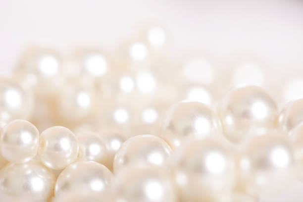 pila di perle sullo sfondo bianco - perlina foto e immagini stock
