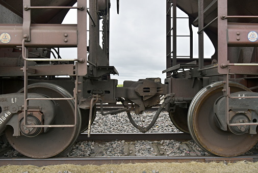 Close up of a suspension unit and wheel on an old railway carriage running on railroad tracks in England.