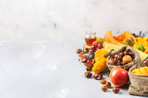istock Fall autumn harvest background with pumpkin apple chestnut corn 845712088