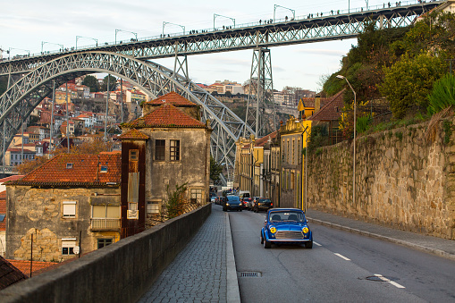 Street in Vila Nova de Gaia and a view of the Dom Luis I bridge, Porto, Portugal.