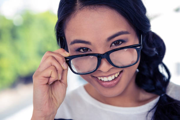 istock Smiling Asian woman holding eyeglasses 845715916
