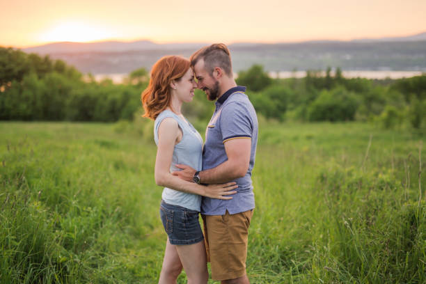 istock Young couple enjoying the sunset in the meadow 845716058