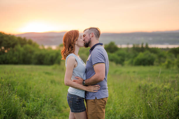 istock Young couple enjoying the sunset in the meadow 845716072