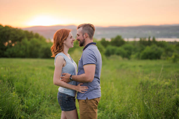 istock Young couple enjoying the sunset in the meadow 845716094