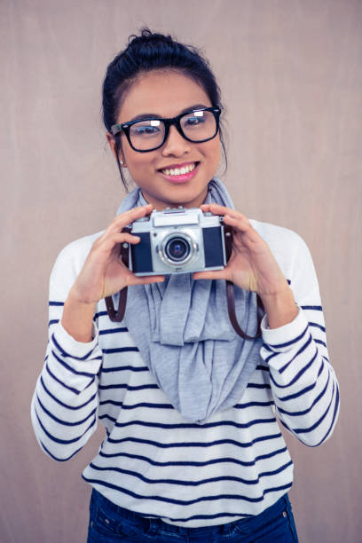 istock Smiling Asian woman holding camera 845716112