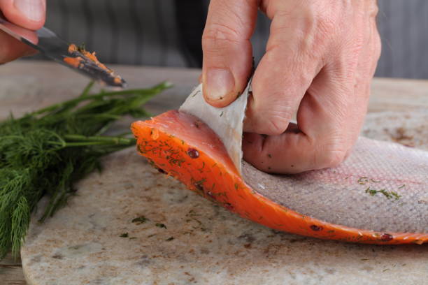 Removing skin from salted salmon stock photo