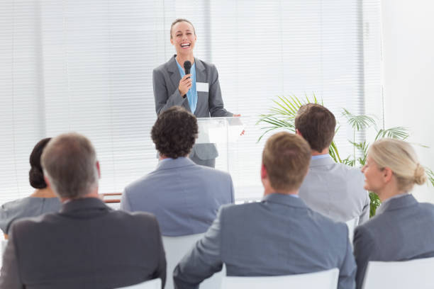 istock Pretty businesswoman talking in microphone during conference 845725440