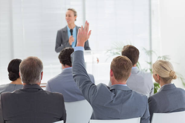 istock Pretty businesswoman talking in microphone during conference 845725456