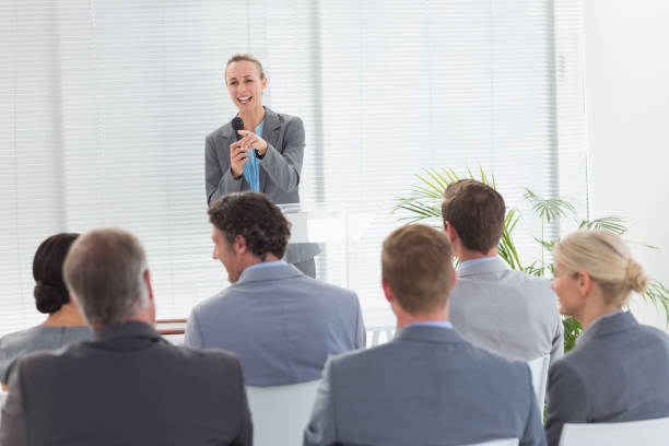 istock Pretty businesswoman talking in microphone during conference 845725466