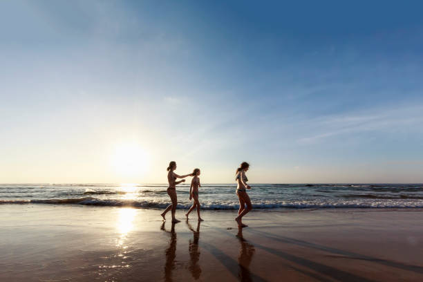 istock Mother waling with her daughters at deserted beach 845732614