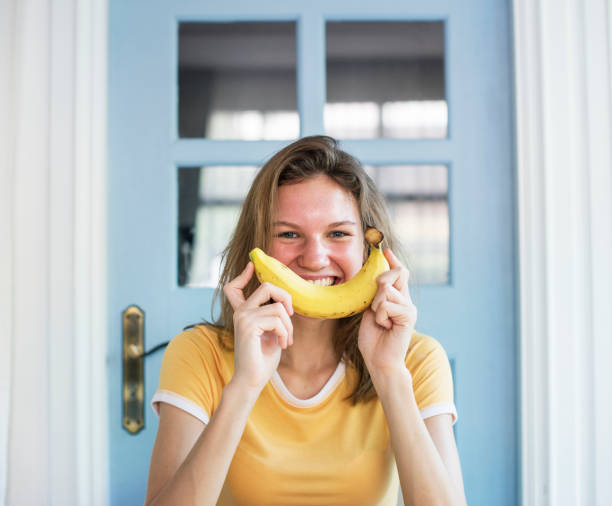 Caucasian woman with banana as smiling