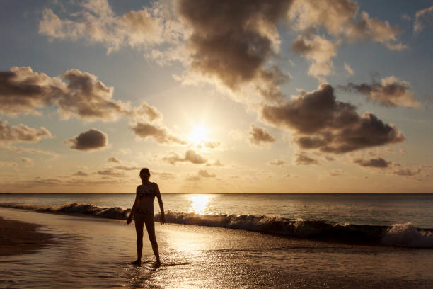istock Girl watching sunset on a deserted beach 845732942