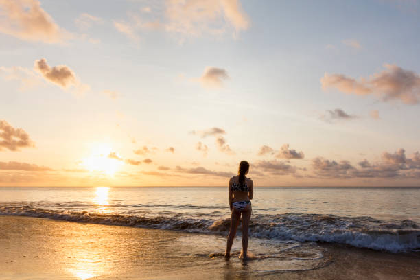 istock Girl watching sunset on a deserted beach 845732944
