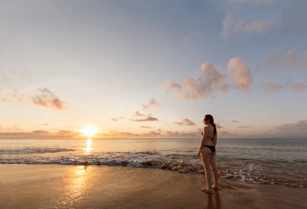 istock Beautiful woman watching sunset over sea 845733002