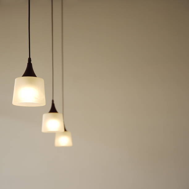 istock three light bulb lamps row hanging in room interior background 845735842