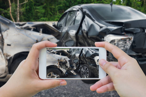 mujer utilizando smartphone tomar fotos del accidente de accidente de coche en la carretera - formulario de reclamación fotos fotografías e imágenes de stock
