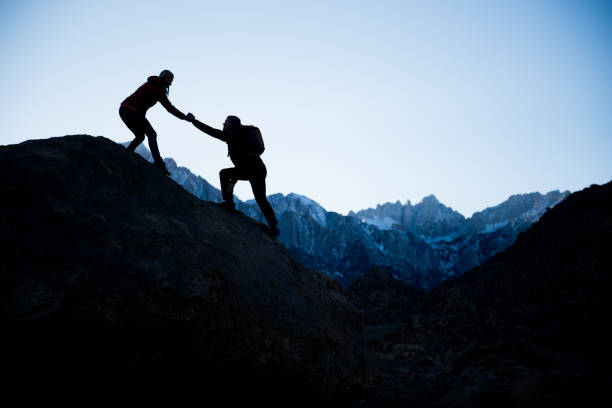 istock couple helping each other in the mountains 845739948