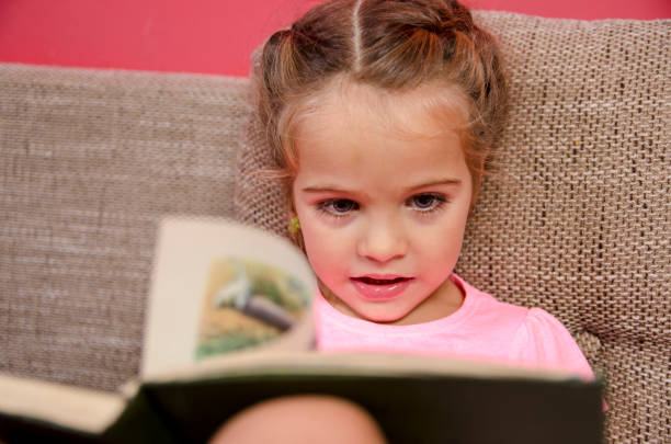 istock Cute little girl reading a book 845754114