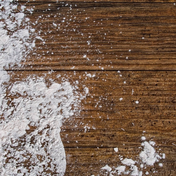 White powder, flour,on rustic wooden board.